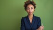 © AGCreative - Confident businesswoman in formal suit holding pen, standing against green background. Professional corporate portrait.