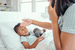 © David/peopleimages.com - Mother, phone call and sick boy in bedroom, check fever and medical consultation for pediatrician advice. Healthcare, feeling forehead and flu with woman monitor, apartment and virtual conversation