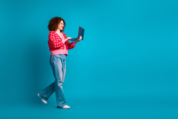 Wall Mural - Full length photo of cheerful pretty lady dressed red cardigan typing modern gadget empty space isolated blue color background