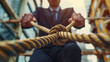 © EmmaStock - A man in a suit is pulling on a rope tied to a knot