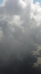 Wall Mural - drone flies over foggy and fluffy clouds. aerial vertical view. blue sky sun and sea fog. abstract a