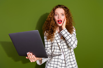 Poster - Photo of attractive young woman frightened hold netbook dressed stylish white plaid clothes isolated on khaki color background