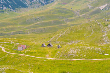 A small mountain village with a dirt road passing through