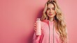 © Berkah - Young sport blonde woman over isolated pink background with sports water bottle.