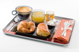 Desayuno en bandeja con café con leche, zumo y bollería. Breakfast on a tray with coffee with milk, juice and pastries.