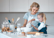 © Maass/peopleimages.com - Kitchen baking, mother and teaching kid cooking, happy and help prepare egg, flour or food ingredients. Mama, love and family fun or woman bonding with daughter, child development support and care