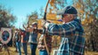 © Jafree - White man aiming longbow at archery range during outdoor archery competition. Concept of sport, target shooting, precision, outdoor activity