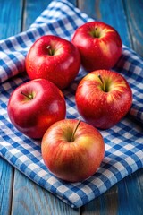 Canvas Print - Fresh red apples on a blue checked cloth.