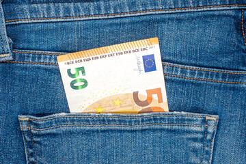 Folded 50 Euro banknote in rear pocket of blue jeans