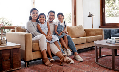 Poster - Asian parents, children and portrait on sofa with hug, care and bonding with love, connection and relax together. Father, mother and daughter kids with smile in living room at family house in Jakarta