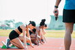 © Courtney/peopleimages.com - Hand, race and person with starter pistol for running, exercise or marathon on track. Starting gun, group and women at field by stadium to get ready for training, cardio or sprint competition outdoor
