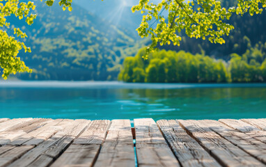 Poster - Sunlit wooden deck overlooking a serene lake with crystal clear water and lush green mountains in the background, creating a peaceful nature scene.