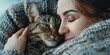 © MK - Woman cuddling a cat with a blanket