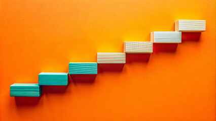 Wooden blocks forming a timeline with milestones on a bright orange background.