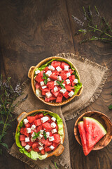 Wall Mural - Fresh watermelon salad with feta cheese and mint on rustic wooden background