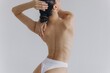 © anatoliycherkas - Cropped back rear view young sexy lady woman with slim body perfect skin wearing nude top bra lingerie stand hold hands on thighs isolated on white background. Lifestyle diet fit concept