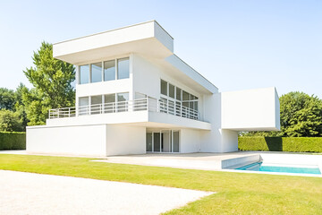 Modern white house with swimming pool and green lawn