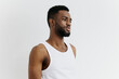 © SHOTPRIME STUDIO - Casual portrait of a confident young man in a white tank top standing against a clean white wall