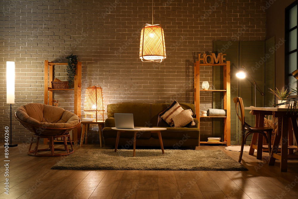 Stylish interior of living room with comfortable sofa at night