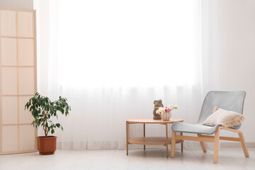 Wall Mural - Coffee table with decoration, chair with pillow and houseplant near light curtain in room