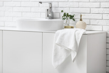 Wall Mural - Clean soft towel on cabinet near white brick wall in bathroom