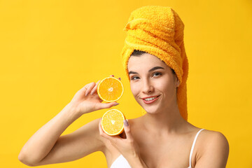 Wall Mural - Beautiful young woman with orange on color background