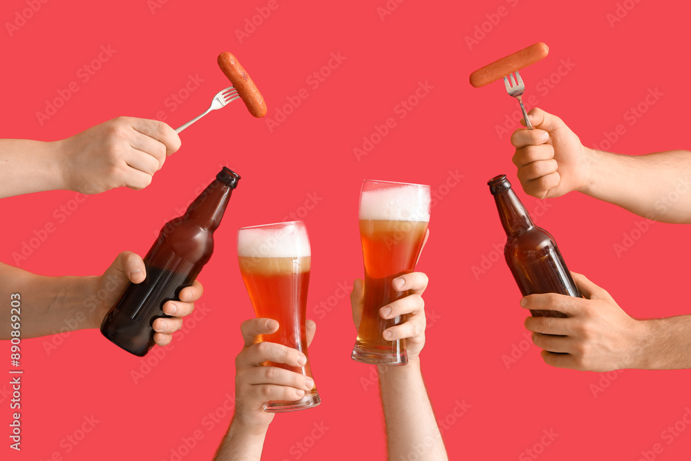 Many hands holding beer glasses, bottles and sausages on red background