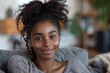 © Just Bella - people, race, ethnicity and portrait concept - happy african american young woman sitting on sofa at home, Generative AI