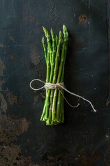 Fresh asparagus spears tied together on a table, ready for cooking or decoration