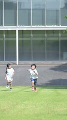 Wall Mural - 校舎の前を走る元気な小学生の全身 未来、希望、元気をイメージした縦型動画