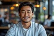 © Rafa - Young Asian businessman standing in an office smiling confidently