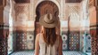 © Damerfie - A tourist, with a straw hat, stands in awe while admiring the intricate and ornate architectural details of a historic building in Morocco, exuding a sense of wonder and cultural appreciation.