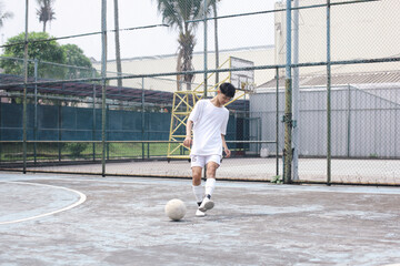 Asian Soccer Player Training Passing Ball At Field