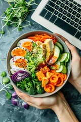 Poster - A bowl of food with a laptop on a table. The laptop is open and the food is colorful and healthy