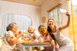 © CandyRetriever  - Group of Happy Asian senior women having meeting party afternoon tea at home. Daughter using mobile phone taking selfie with elderly retired mother and friends during drinking tea and eating bakery
