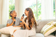© CandyRetriever  - Happy Asian women family senior mature mother and daughter spending time together at home. Elderly mom and adult child and adult daughter singing karaoke song with dancing together in living room.