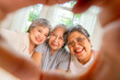 © CandyRetriever  - Group of Happy Asian senior mature women relaxing on sofa in living room. Elderly retired woman friends enjoy and fun reunion meeting using mobile phone taking selfie or vlogging together at home.