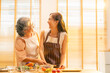 © CandyRetriever  - Happy Asian family enjoy and fun indoor healthy lifestyle cooking and having dinner together at home. Senior mature mother teaching adult daughter making vegan food vegetables salad in the kitchen