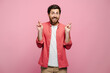 © Maria Vitkovska - Young Caucasian man isolated on pink background crossing fingers for luck