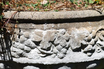 Sticker - Close-up shot of a stone planter with plants growing out of it, suitable for use in gardening or home decor contexts.