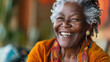 © Erwin - An elderly black woman with beautiful gray hair and simple earrings smiles warmly, representing wisdom, depth of experience, and a joyful spirit, draped in colorful attire.