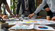 © Erwin - An office meeting scene featuring team members with diverse backgrounds actively discussing various documents spread out on a table, exemplifying teamwork and collaboration in a contemporary workplac