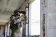 © New Africa - Military mission. Soldier in uniform with binoculars inside abandoned building, space for text