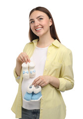 Sticker - Expecting twins. Pregnant woman holding two pairs of baby shoes on white background