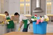 © New Africa - Professional janitors working in kitchen, focus on bucket with supplies. Cleaning service