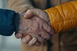 © Milos - A close-up of a handshake between two individuals wearing contrasting jackets, symbolizing unity despite differences, emphasizing human connection, trust, and collaboration.