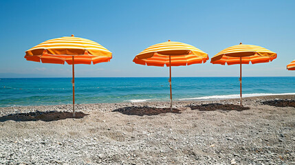 Bright orange and yellow beach umbrellas lined up on a pebbly shore with the ocean in the background, creating a vibrant seaside atmosphere.