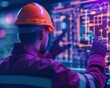 © sorrakrit - A worker in an orange helmet operates advanced technology in a digital environment, showcasing modern industrial innovation.