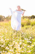© laowaika - Romantic girl in white dress is walking and dreaming on field at sunset