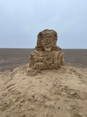 Damaged sand art sculpture on the beach